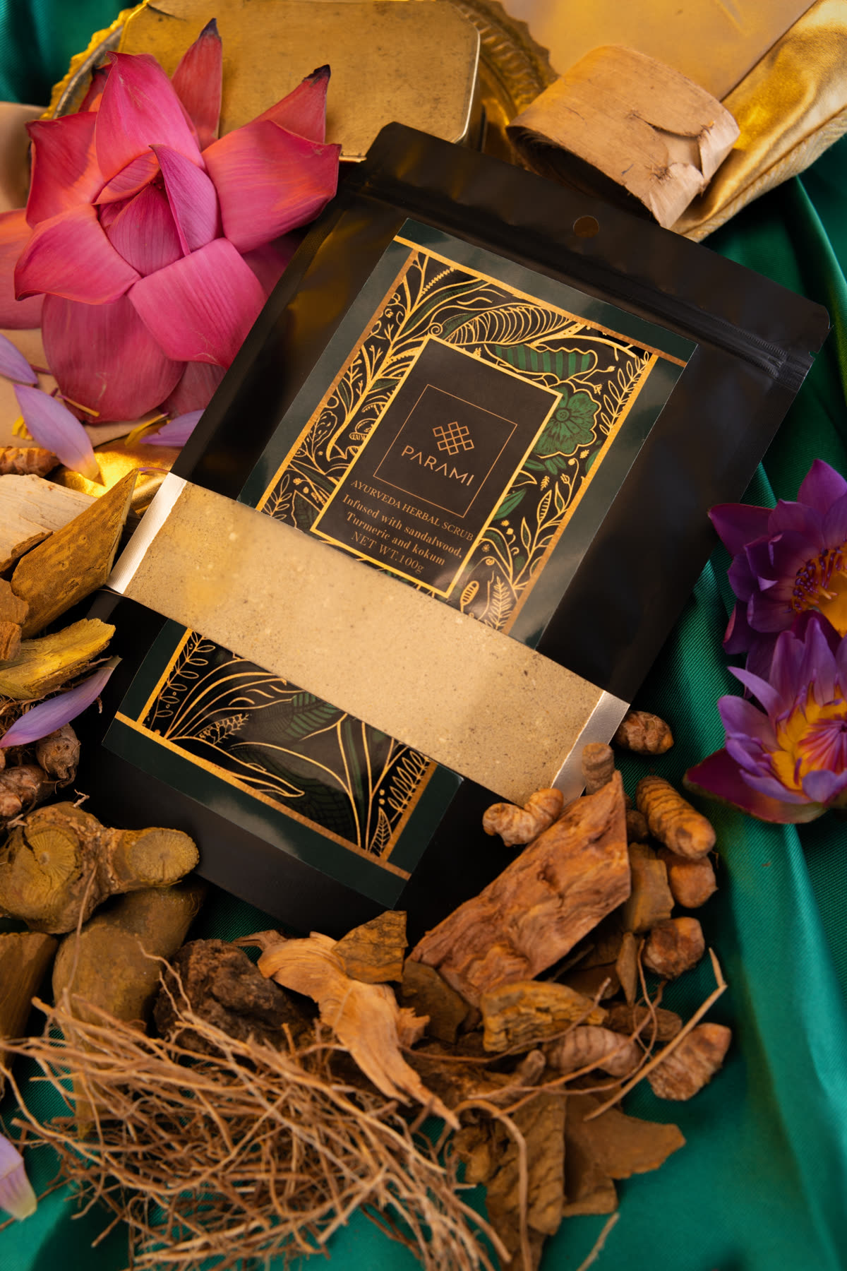 The pouch from above, among dried roots, bark, turmeric and pink and violet water lilies